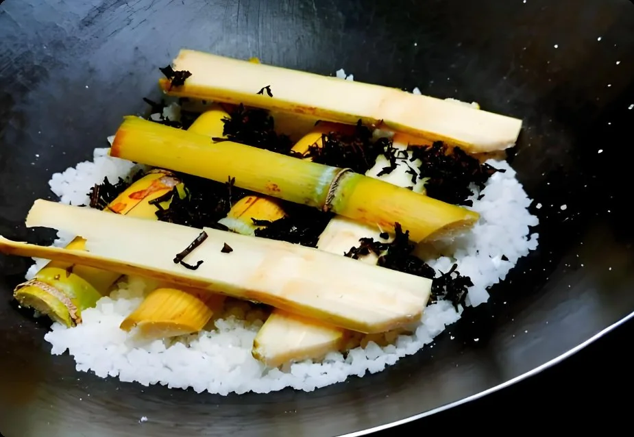 粗盐炒热后铺上陈皮与茶叶,破开的甘蔗以井字型架在上面,鲮鱼置于甘蔗上准备熏制