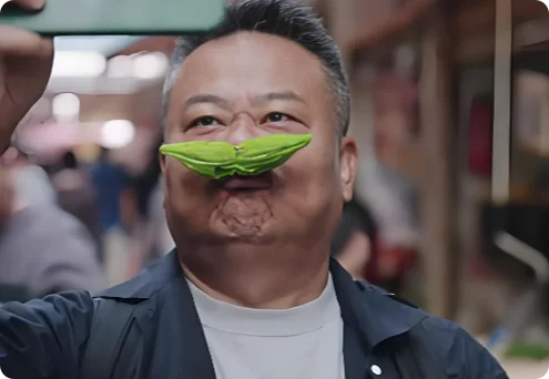 陈晓卿手持苦瓜自拍，街头背景虚化，表情轻松有趣