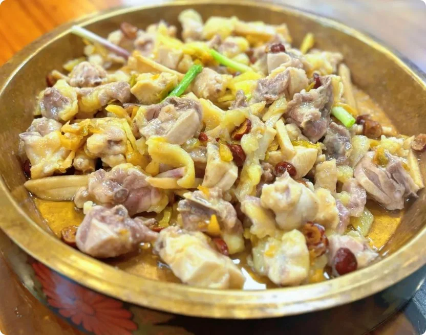 铜盘蒸鸡，鸡肉切块铺姜丝红枣，热气腾腾油光润泽