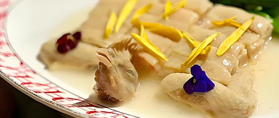 江南百花鸡成菜：鸡件呈日字形摆盘、复原整鸡形态，鸡皮酿手打虾胶，撒上夜来香花瓣