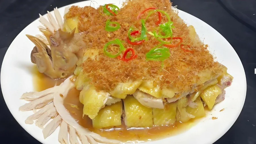 姜茸鸡成菜：鸡件齐整码盘，面上铺一层金黄蓬松的炸姜茸，青红椒圈点缀，盘底一汪豉油汁